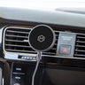 Image of a Mighty Mount MagSafe Wireless Charger mounted on a car's air vent. The device features a round, modern design with a MagSafe logo, indicating compatibility with MagSafe-enabled smartphones. The charger is positioned within reach of the driver, subtly integrated into the vehicle's interior for convenient access. The background shows a view of the car's interior, emphasizing the focus on the charger.
